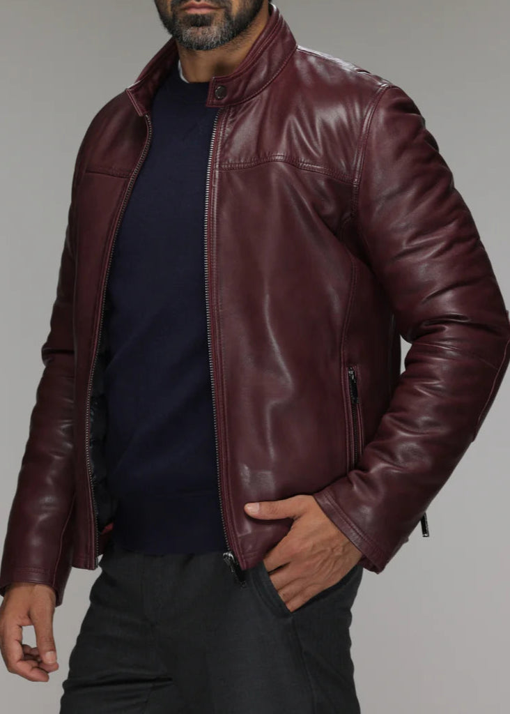 Man wearing a maroon leather jacket on a gray background