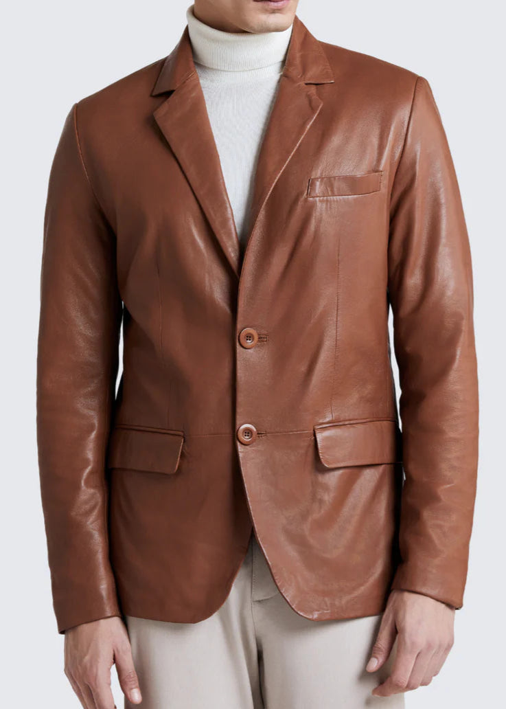 Man wearing a brown leather blazer over a white turtleneck on a light gray background